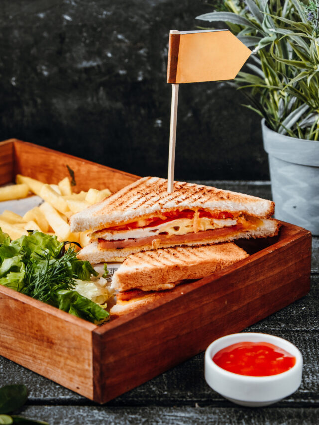 cheese sandwich with french fries on wooden board