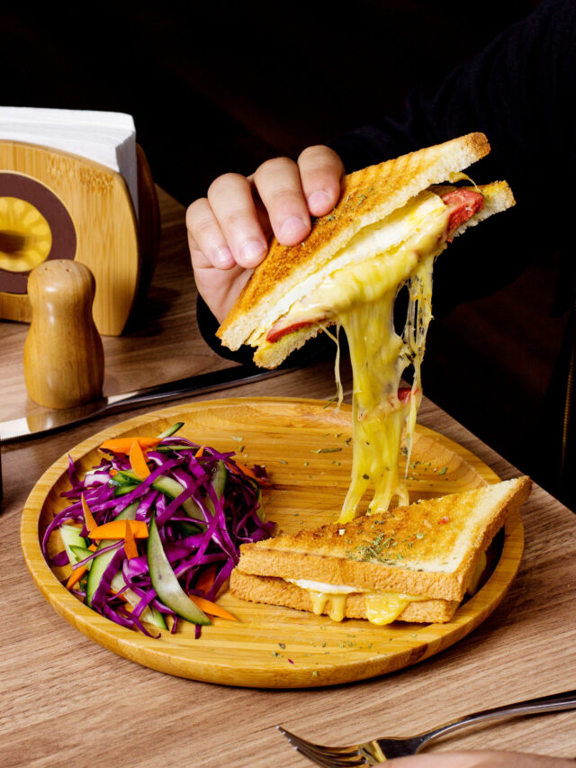 man eats sandwich served with salad